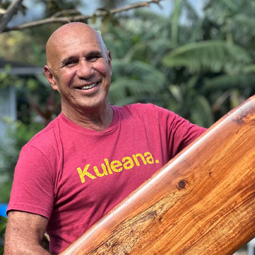 smiling man holding surfboard