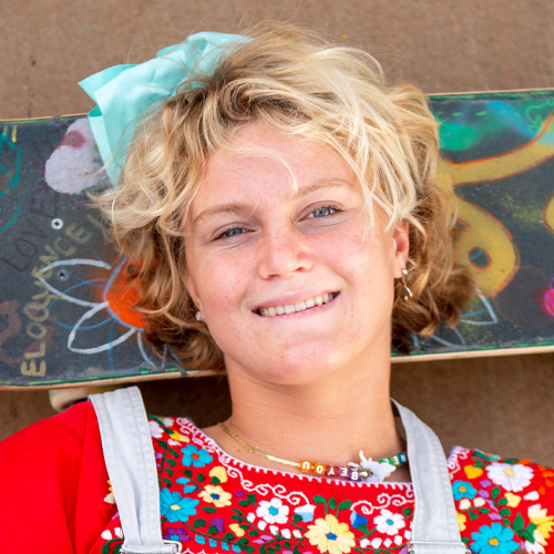 smiling woman laying on skateboard